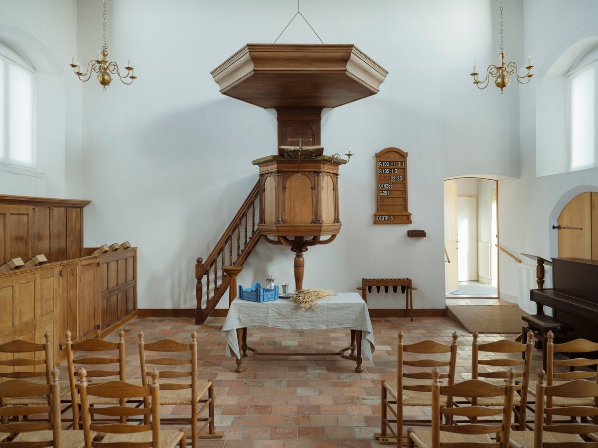 A traditional church sanctuary with a wooden pulpit and communion table